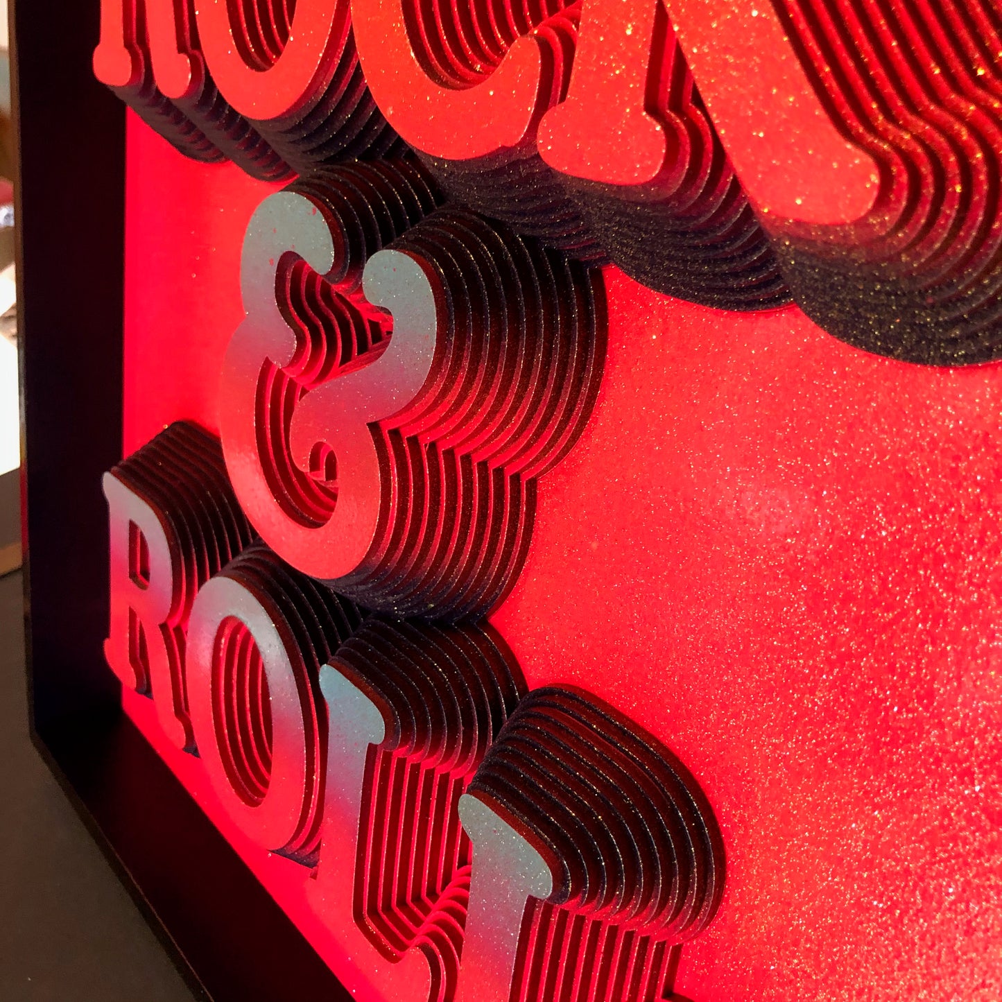Multiple layered laser cuts finished in hot pink and glitter with a glossy varnish. Built in to a hand made box frame in complimentary colours. pop art cooper font rock and roll maximalist artwork wallart